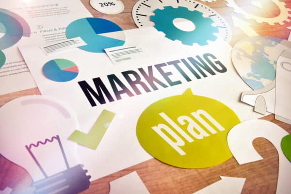 The words "Marketing Plan" with a variety of analytic charts, gears, check marks, and other related marketing shapes.